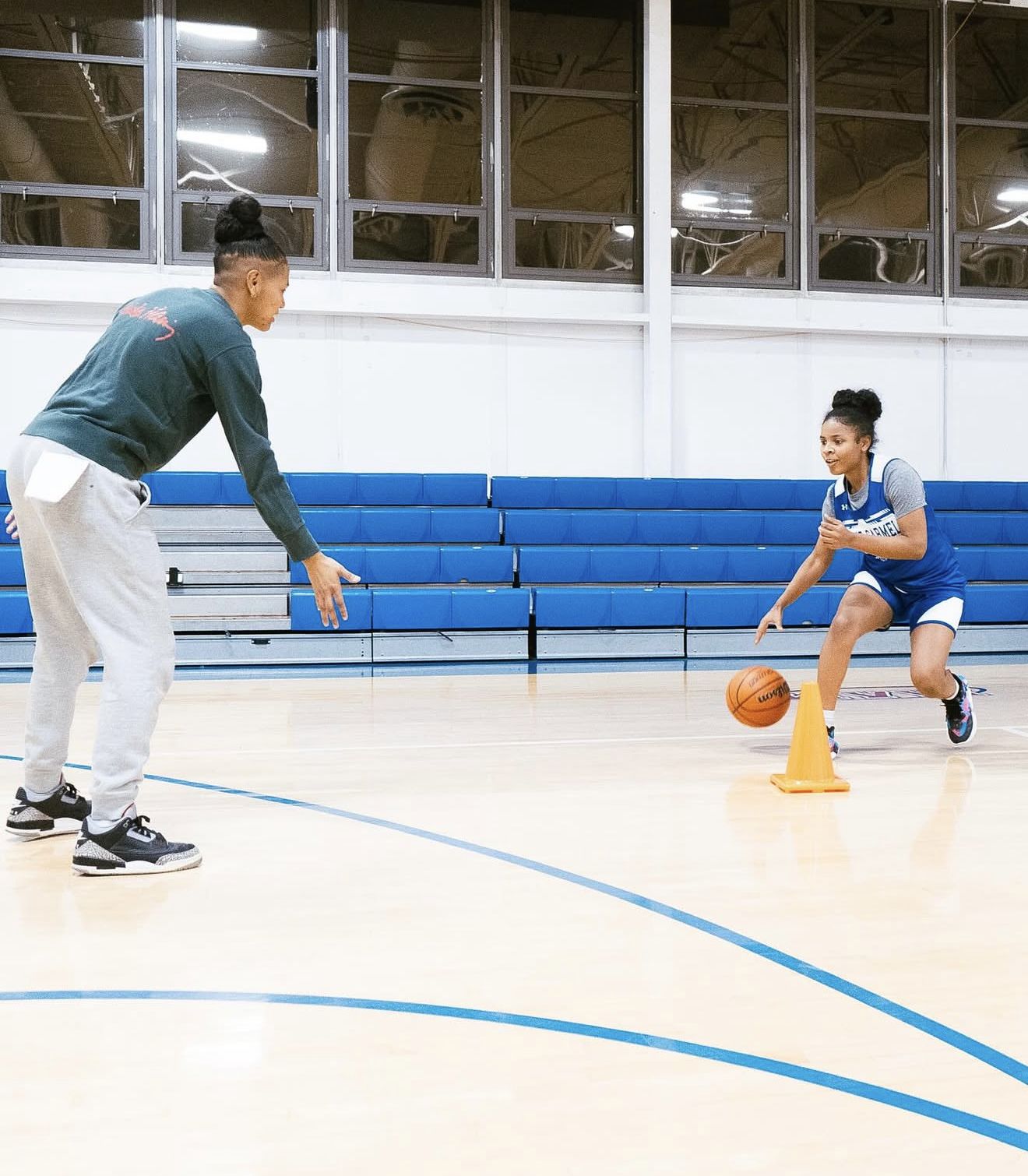 Coach Nay guarding a young player through a ball-handling drill